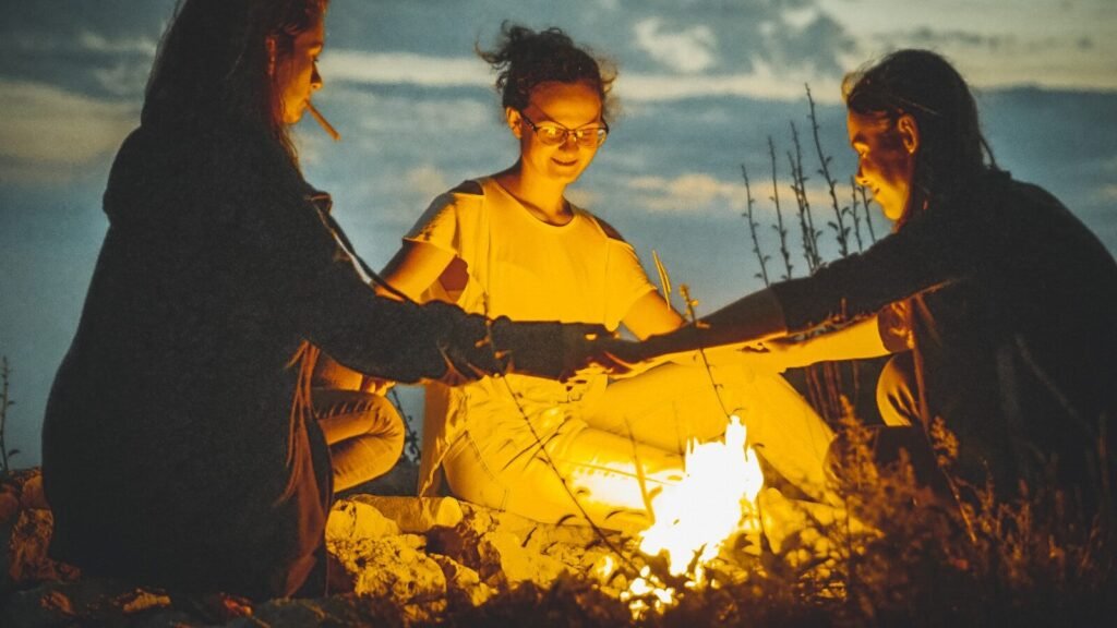 a group of people sitting around a campfire