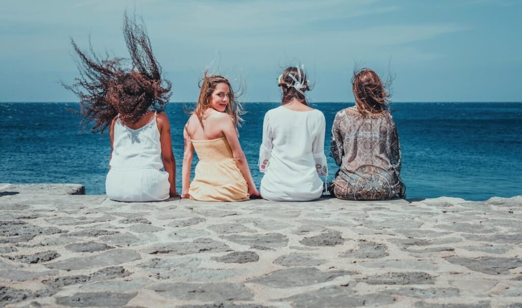 four women sitting on dock